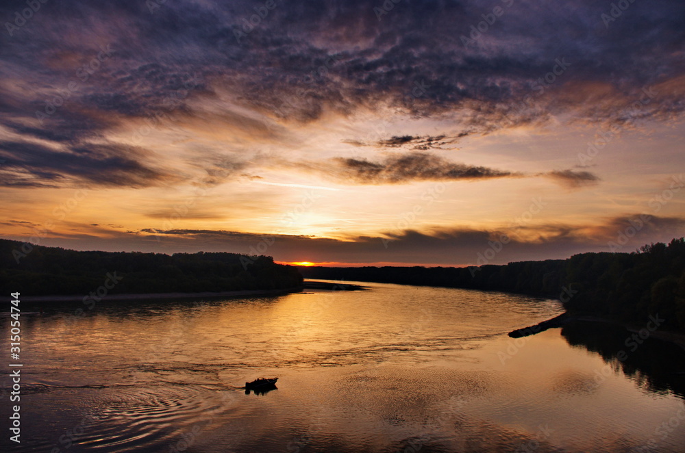 Fototapeta premium Beautiful sunset panorama over the river. Colorful twilight sky Sunset over the river