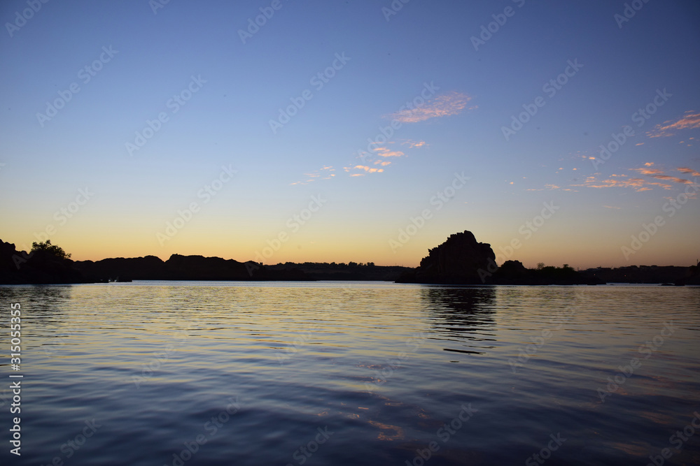 River Nile/ beautiful view for Aswan Egypt and Nubian Egyptian culture. sailing boat sailing in the River Nile and harbor with birds and local houses on the 2 sides 