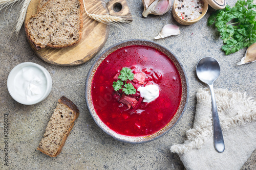 Beetroot soup: Traditional Ukrainian or Russian borscht with sour cream in a bowl, top view photo