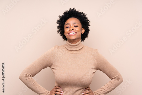 African american woman over isolated background posing with arms at hip and smiling