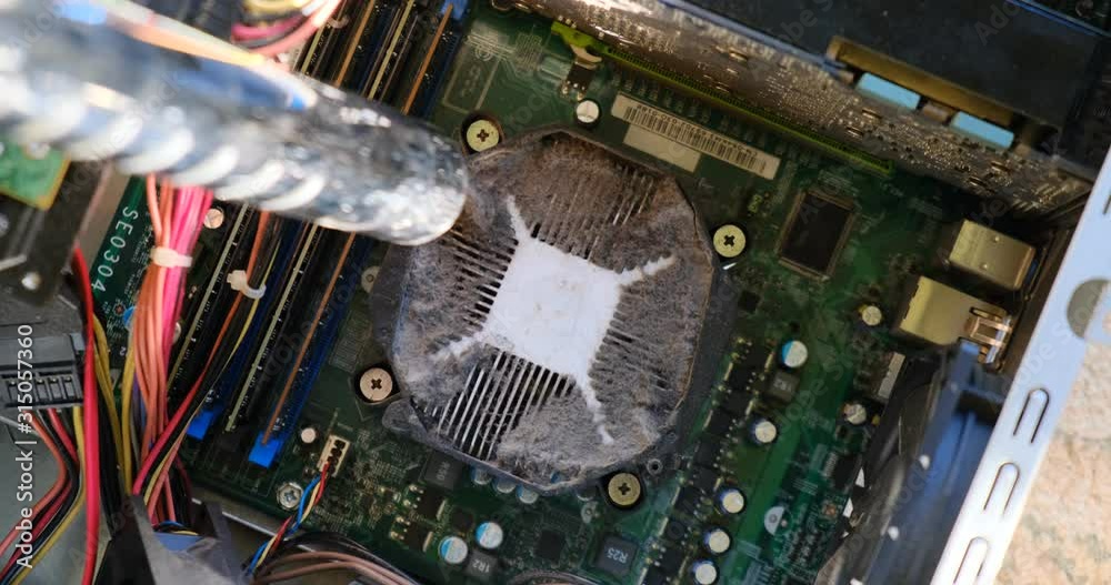 Vacuuming dust from a heatsink on top of a CPU, inside a computer case