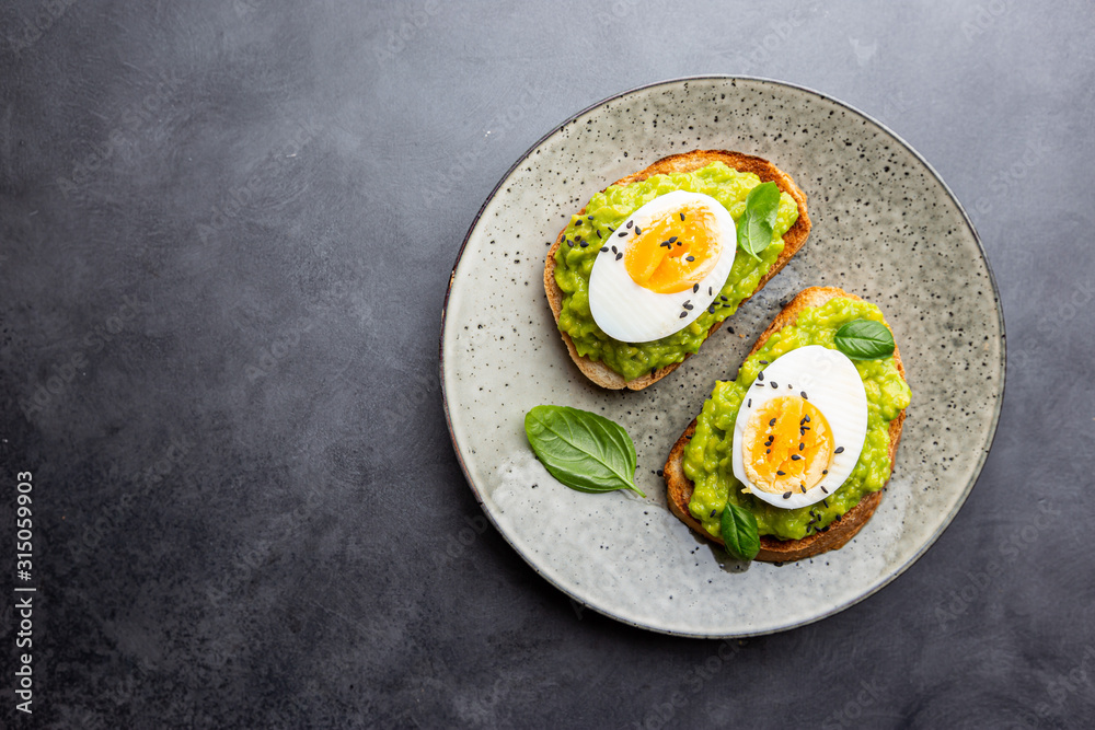 Healthy breakfast, toast with avocado and egg, top view, copy space. Vegetarian food concept