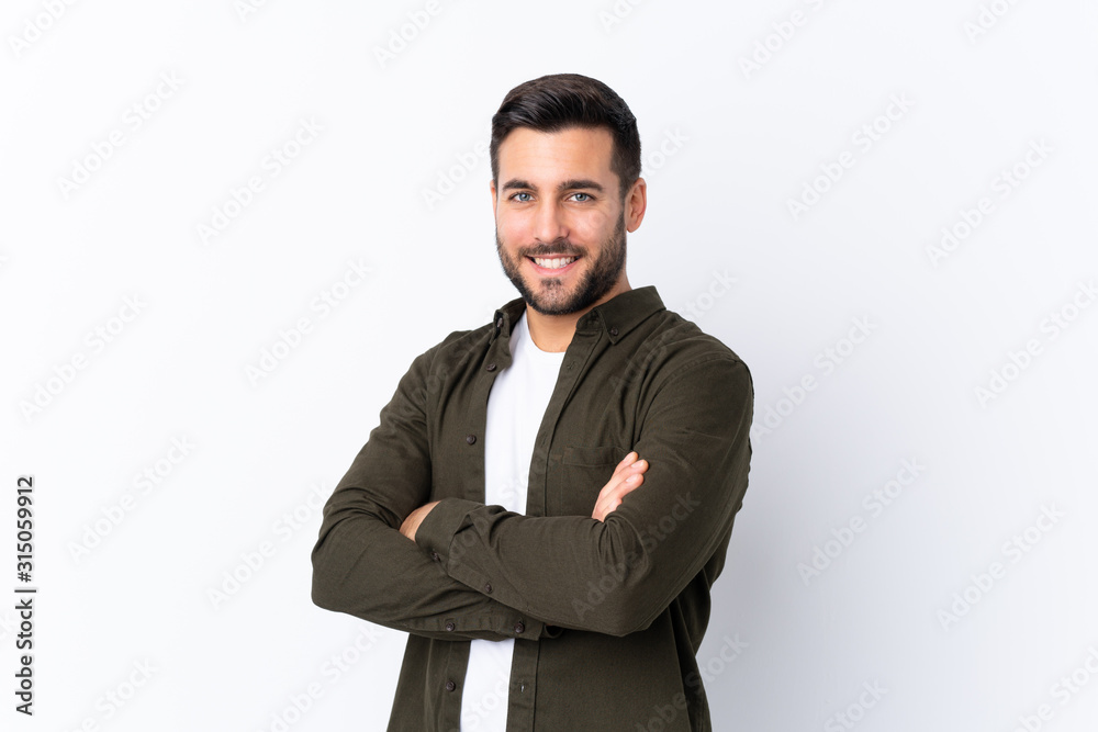 © luismolinero - Young handsome man with beard over isolated white background with arms crossed and looking forward © luismolinero - Young handsome man with beard over isolated white background with arms crossed and looking forward