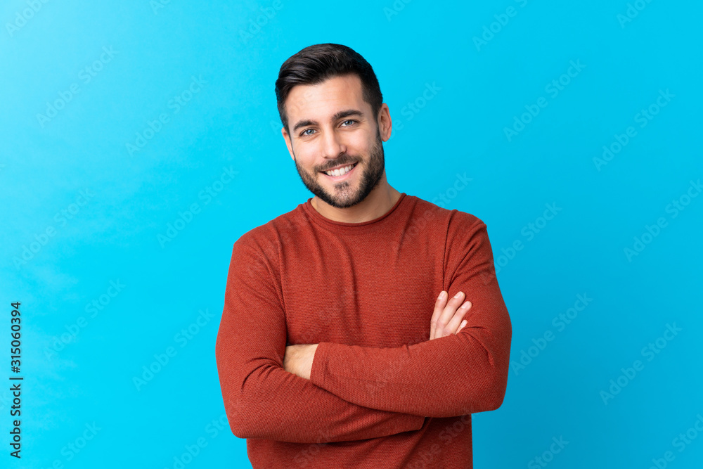 Young handsome man with beard over isolated blue background laughing Young handsome man with beard over isolated blue background laughing