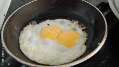 Double Yolker Egg with Two Yolks Frying in Pan, Closeup Wraparound Shot photo