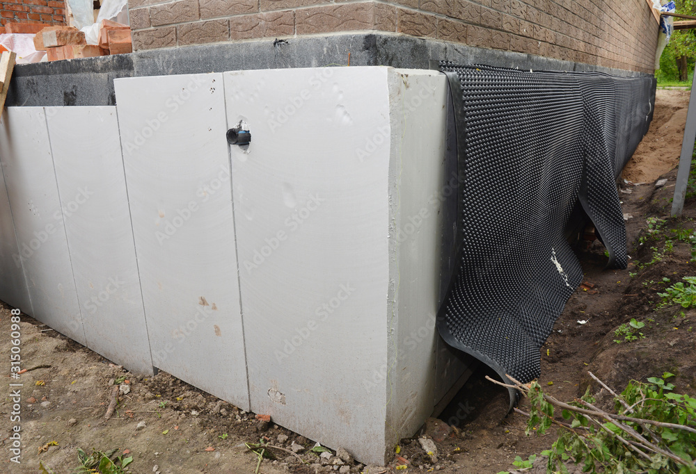 Foundation wall insulation, damp proofing on the house corner. House