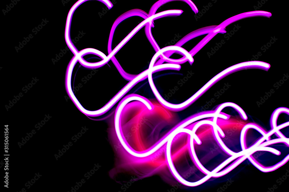 Obraz premium Abstract image of neon pink or lilac lights on a dark background.