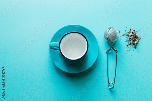 Blue background, strainer and poured a handful of tea Bai Hao Yin Zhen Silver needles, useful properties of tea, raises the immune system, providing effective protection from disease