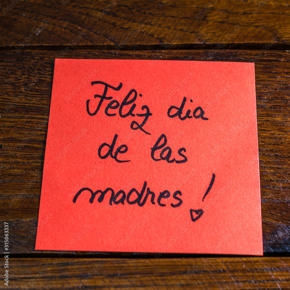 Writing happy mother`s day in Spanish (feliz dia de las madres) on memo ...