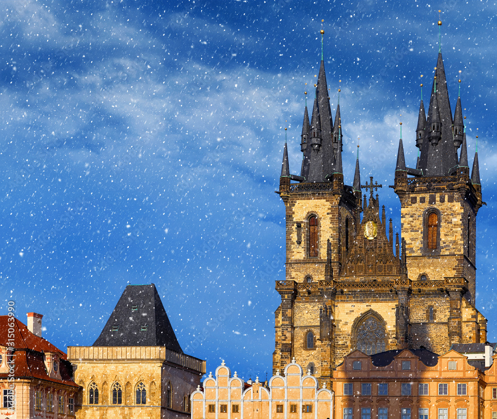 Christmas in Prague, Czech Republic. Central square old town (Staromestska) in front of Church of Our Lady Before Tyn. Snowfall snow in sunny holiday winter day.