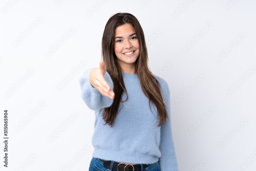 Teenager girl over isolated white background shaking hands for closing a good deal Teenager girl over isolated white background shaking hands for closing a good deal