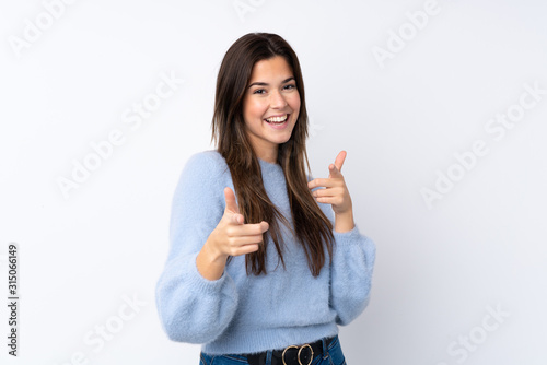Teenager girl over isolated white background pointing to the front and smiling