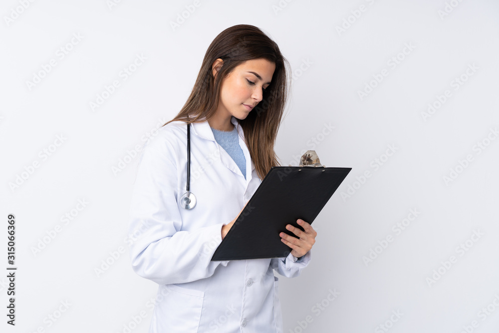 Teenager girl over isolated white background wearing a doctor gown and holding a folder Teenager girl over isolated white background wearing a doctor gown and holding a folder