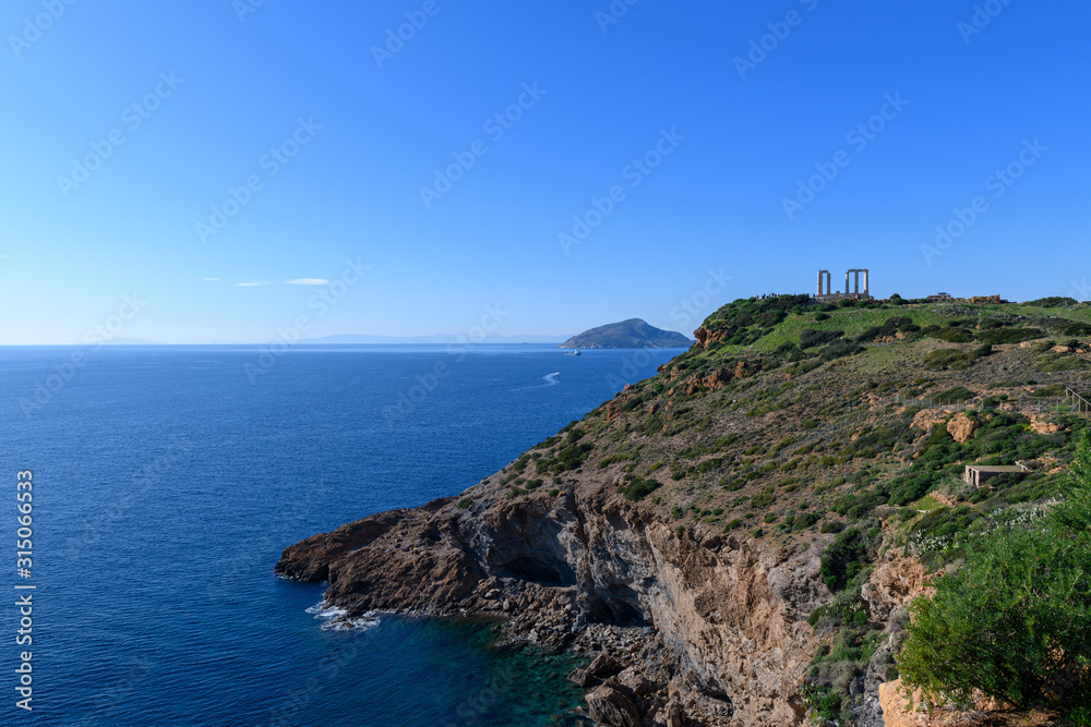 Beautiful rocky coastline and temple of Poseidon on Cape Sounion