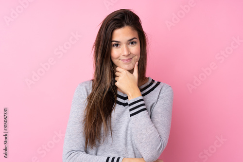 Teenager girl over isolated pink background laughing