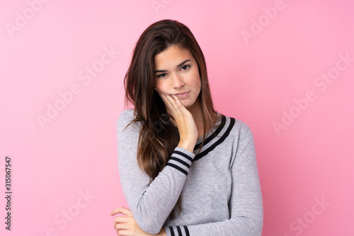 Teenager girl over isolated pink background unhappy and frustrated