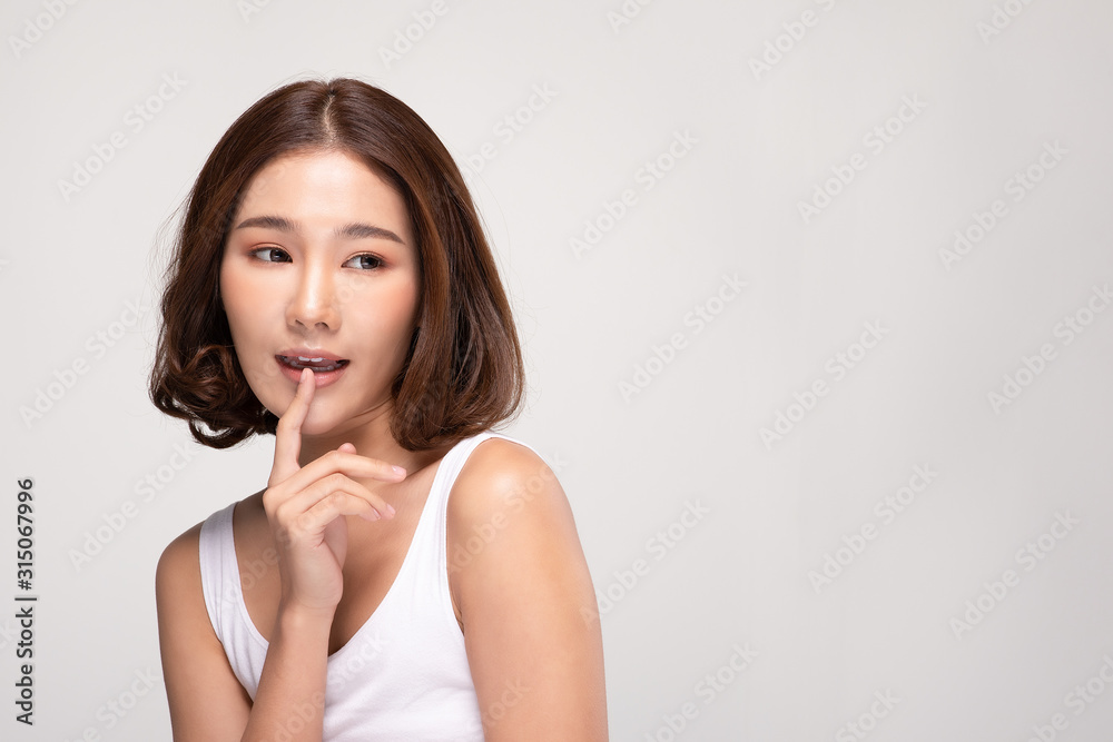 Beautiful Asian woman with short hair looking at camera making surprise and quiet sign forefinger touch on lips with clean and fresh skin,isolated on gray background,Beauty and Cosmetics Concept Beautiful Asian woman with short hair looking at camera making surprise and quiet sign forefinger touch on lips with clean and fresh skin,isolated on gray background,Beauty and Cosmetics Concept