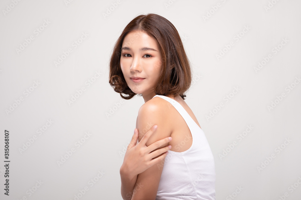 Beautiful Young Asian Woman with short hairs Touching Shoulder feeling so happy and cheerful with healthy Clean and Fresh skin,isolated on gray background,Beauty Cosmetology Concept Beautiful Young Asian Woman with short hairs Touching Shoulder feeling so happy and cheerful with healthy Clean and Fresh skin,isolated on gray background,Beauty Cosmetology Concept
