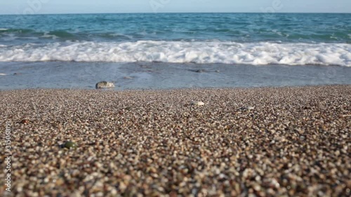 Low angle video shoot of blue sea water splashing at stony beach outside. Turkey. Natural background. Real time full hd footage.