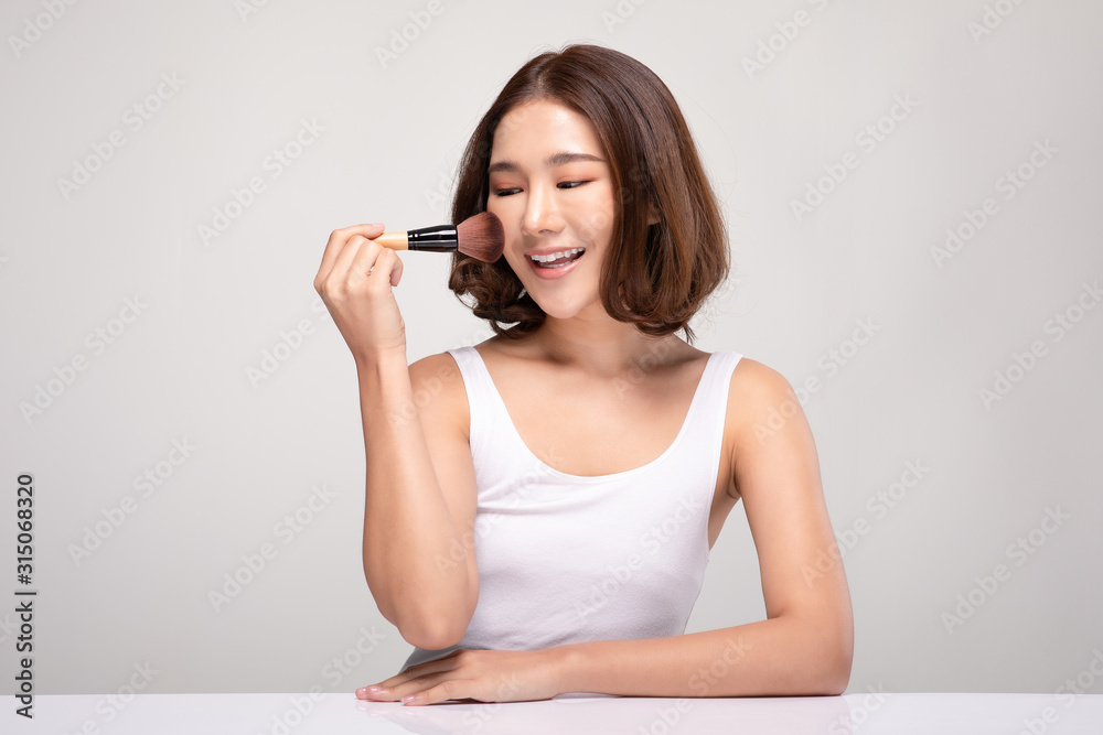 Beautiful Asian young woman smile and holding make up brush with healthy Clean and Fresh skin feeling so happiness and cheerful,Isolated on white background,Beauty Cosmetics Concept Beautiful Asian young woman smile and holding make up brush with healthy Clean and Fresh skin feeling so happiness and cheerful,Isolated on white background,Beauty Cosmetics Concept