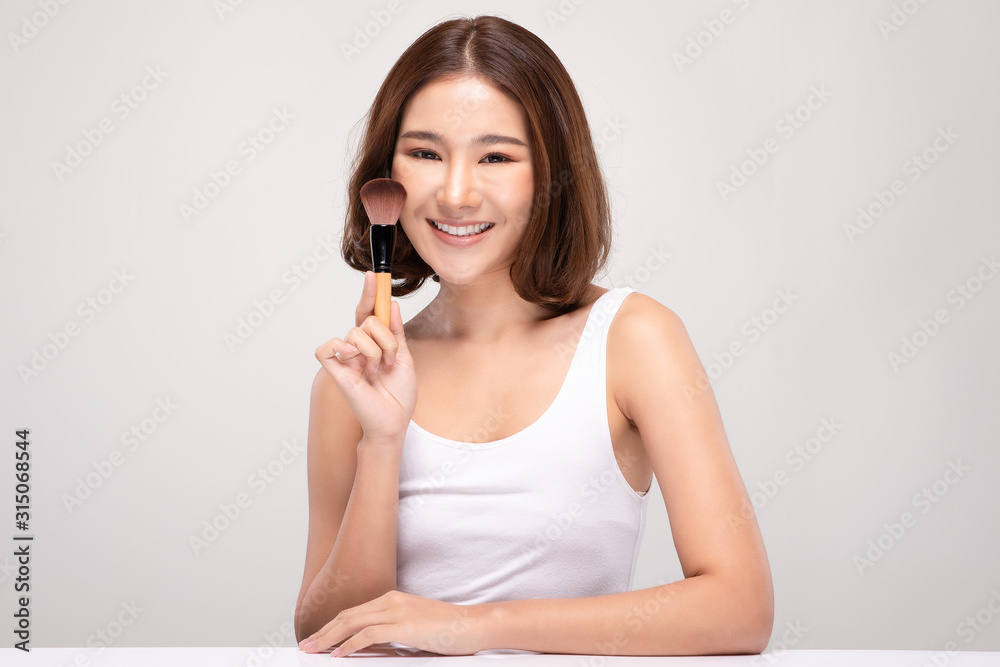Beautiful Asian young woman smile and holding make up brush with healthy Clean and Fresh skin feeling so happiness and cheerful,Isolated on white background,Beauty Cosmetics Concept Beautiful Asian young woman smile and holding make up brush with healthy Clean and Fresh skin feeling so happiness and cheerful,Isolated on white background,Beauty Cosmetics Concept