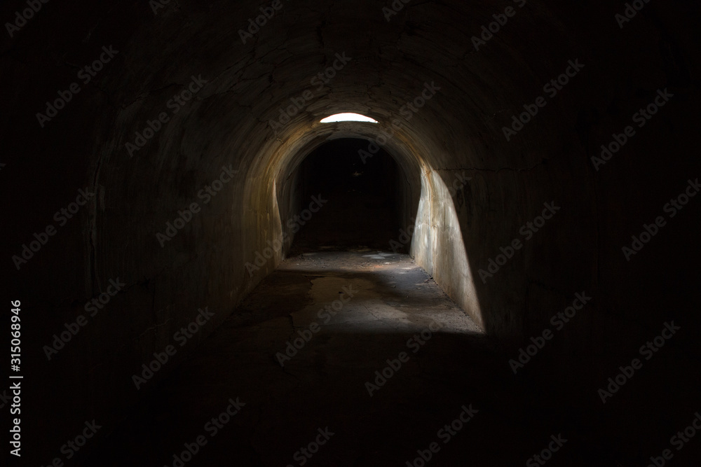 A gloomy dark underground corridor, sealed through a hole in the ceiling at Fort Pospelova on the Russian island in Vladivostok.