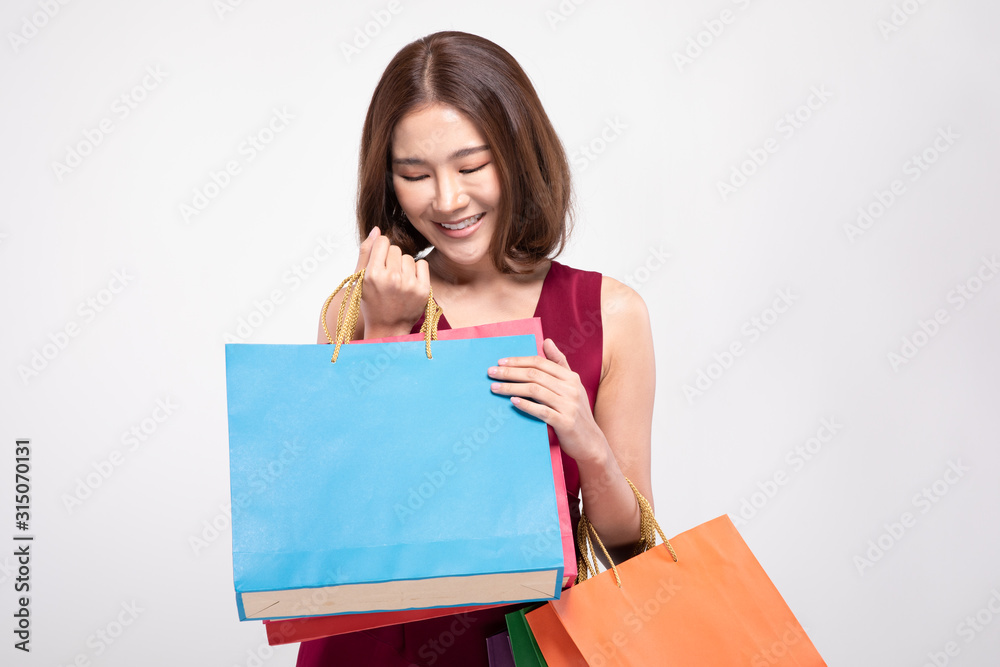 Shopping Asian woman with short hairs smile wearing red dress Holding Shopping bags,Cheerful and happiness emotional,Enjoy Shopping in black friday sale,Isolated on gray background,Shopping Concept Shopping Asian woman with short hairs smile wearing red dress Holding Shopping bags,Cheerful and happiness emotional,Enjoy Shopping in black friday sale,Isolated on gray background,Shopping Concept