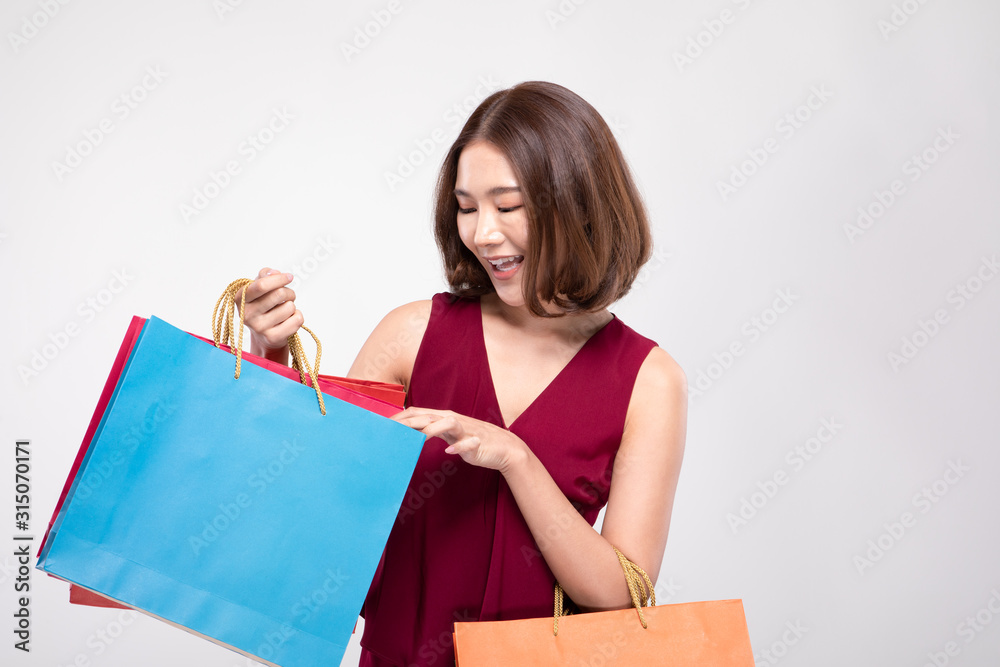 Shopping Asian woman with short hairs smile wearing red dress Holding Shopping bags,Cheerful and happiness emotional,Enjoy Shopping in black friday sale,Isolated on gray background,Shopping Concept Shopping Asian woman with short hairs smile wearing red dress Holding Shopping bags,Cheerful and happiness emotional,Enjoy Shopping in black friday sale,Isolated on gray background,Shopping Concept