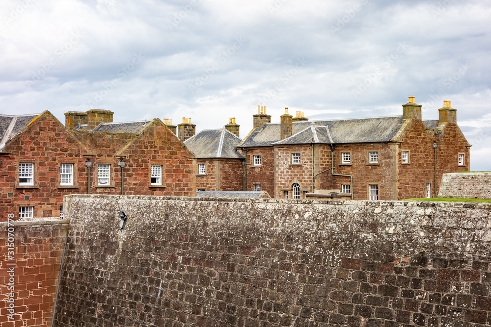 Red brick barracks in historical Fort George, Scotland with a ditch