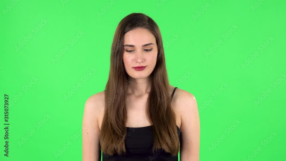 Young woman stands waiting on green screen Young woman stands waiting on green screen