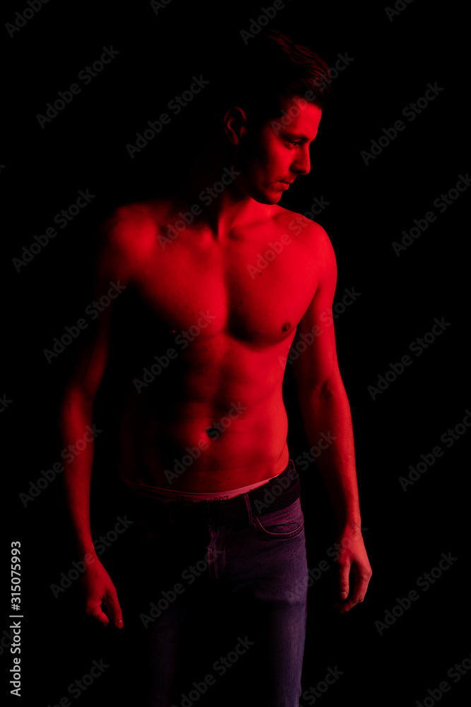 Fototapeta premium Man in studio with red and blue colors. Look at camera and smile