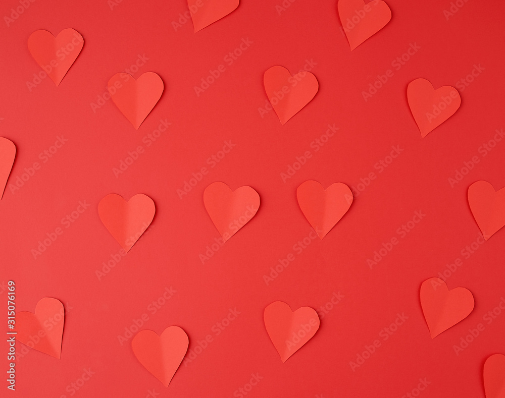 hearts cut out of red paper on a red background, festive backdrop for Valentine's Day