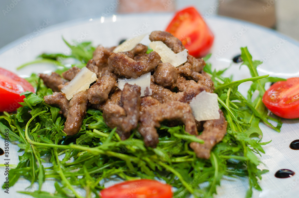 Tasty and juicy grilled meat with arugula, cheese, tomato sauce and spices Tasty and juicy grilled meat with arugula, cheese, tomato sauce and spices