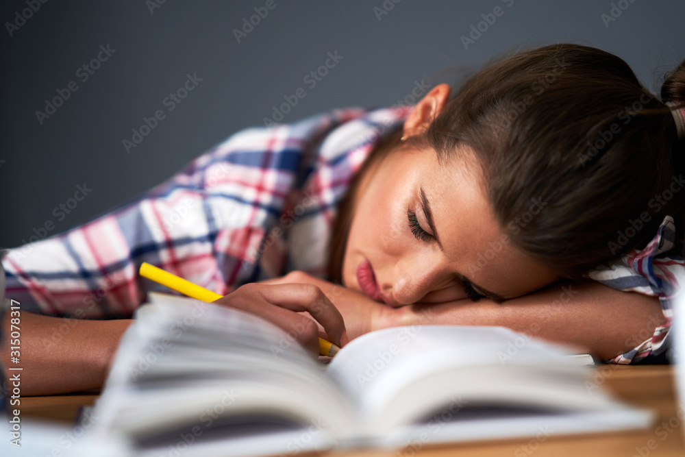 Tired female student learning till late at home Tired female student learning till late at home