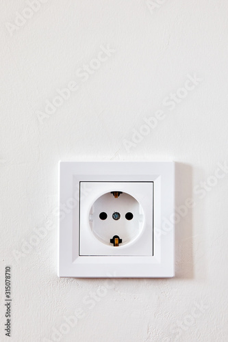 Electrical outlet socket on the white wall