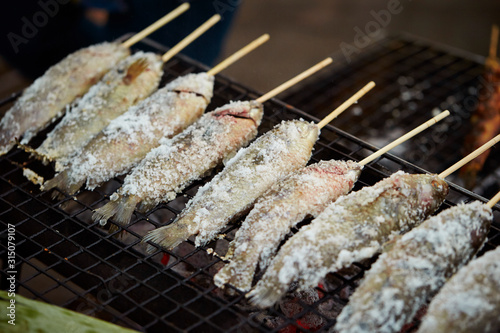 Salted fish skewer on grill  photo