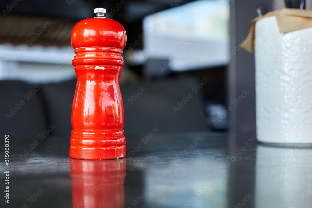 Red pepper mill on the grey concrete table background Red pepper mill on the grey concrete table background