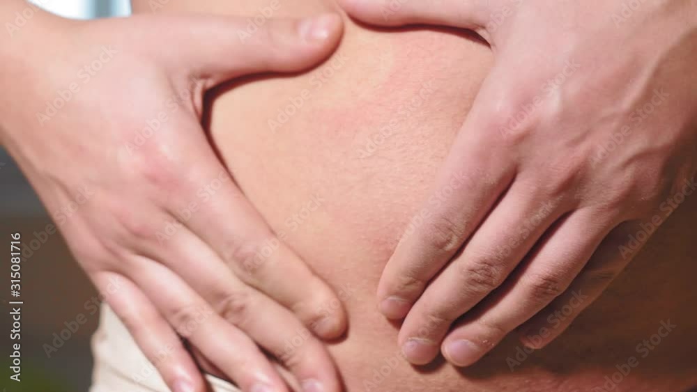 young caucasian man grabbing the fat of his hairy stomach. belly fat, weight loss, overweight young caucasian man grabbing the fat of his hairy stomach. belly fat, weight loss, overweight
