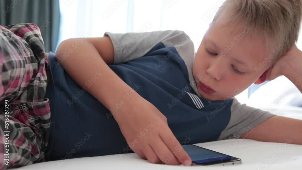 Funny little kid typing message using modern social media messenger and smartphone technology. Real time full hd video footage. Funny little kid typing message using modern social media messenger and smartphone technology. Real time full hd video footage.