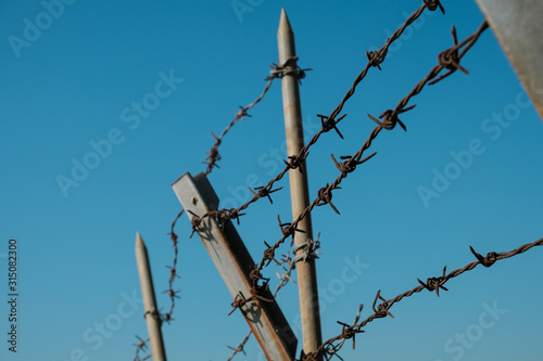 barbwire closeup on fence, barbed wire on blue sky