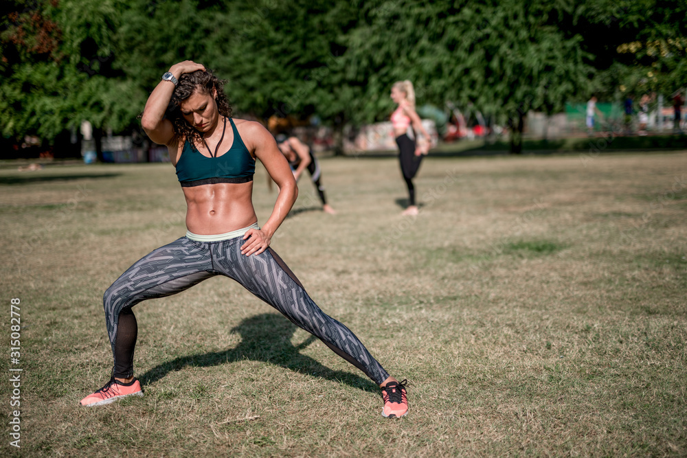 Young sportswoman stretching and preparing to run. Young sportswoman stretching and preparing to run.