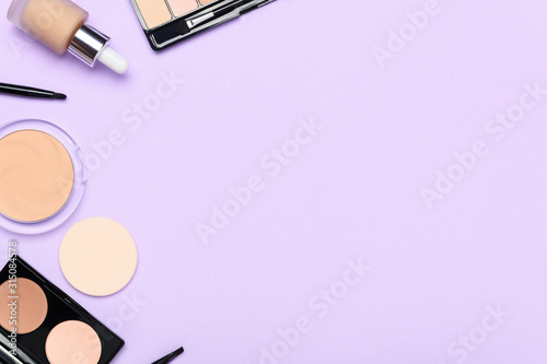 Facial skin correction cosmetics on light purple background. Liquid concealer, facial powder, brushes composition with place for text. Feminine makeup products blank horizontal backdrop.