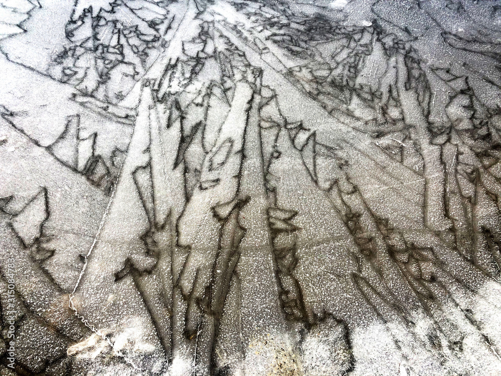 Cracked ice of frozen lake in mountains close-up. Natural background. Copy space Cracked ice of frozen lake in mountains close-up. Natural background. Copy space