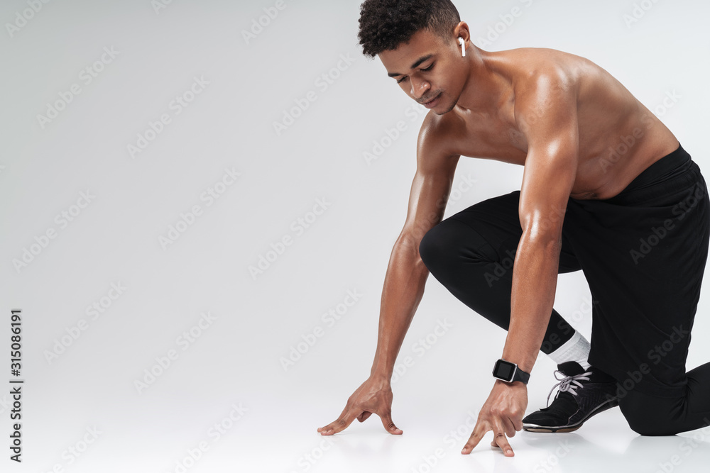 Obraz premium Photo of shirtless african american man using earpod while working out
