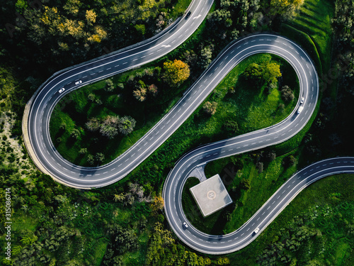 Fotografía Aerial view of winding curved road with helicopter parking in Italy