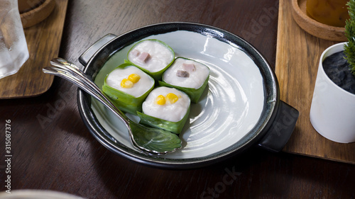 Canvas-taulu Famous Thai Pudding with Coconut topping on banana leaf(Tako) , Thai pudding with coconut topping, Thai dessert,Tako in white and black plate
