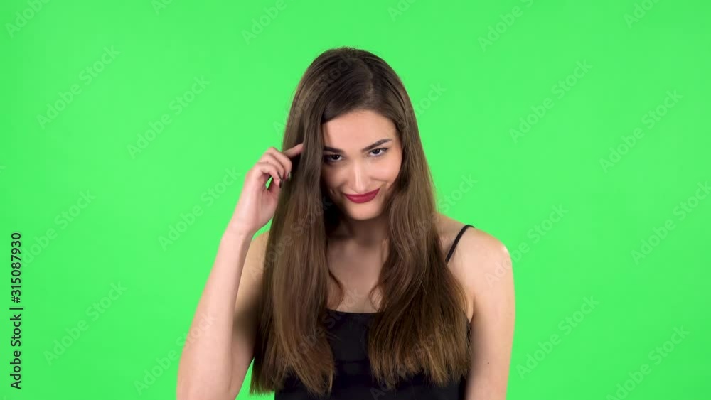 Indignant woman throwing up hands expressing she is innocent, twists his finger at his temple. Green screen Indignant woman throwing up hands expressing she is innocent, twists his finger at his temple. Green screen