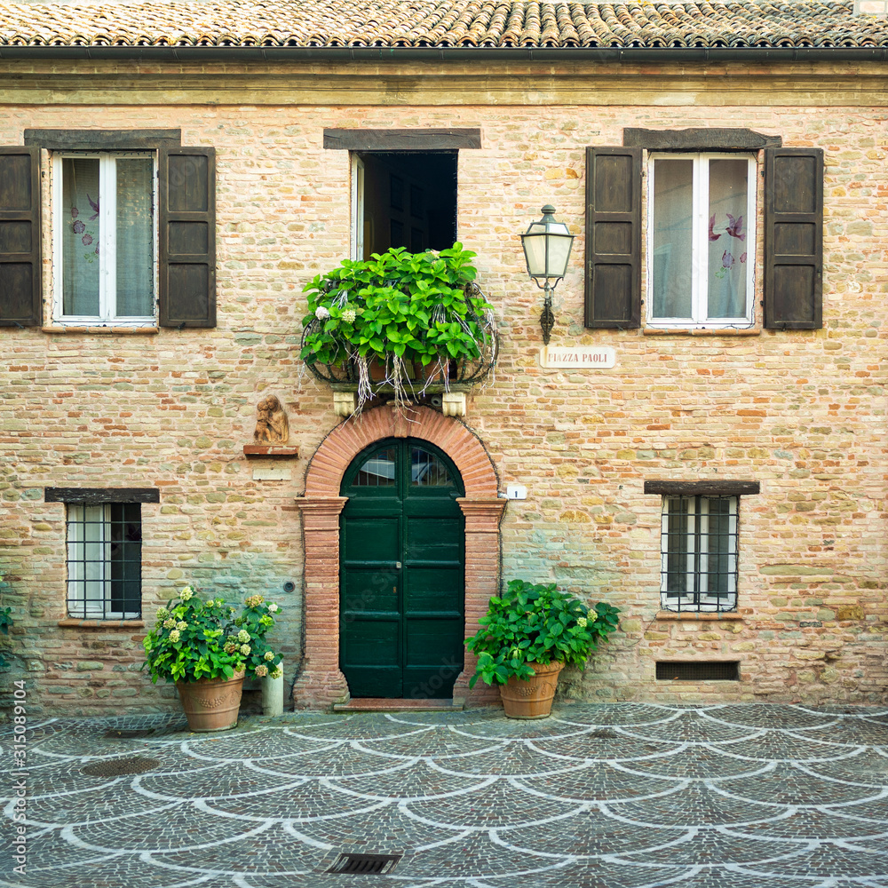 Old palace facade, in the small village of Fiorenzuola di Focara (Marche, Italy) over the cliffs of Adriatic Sea.