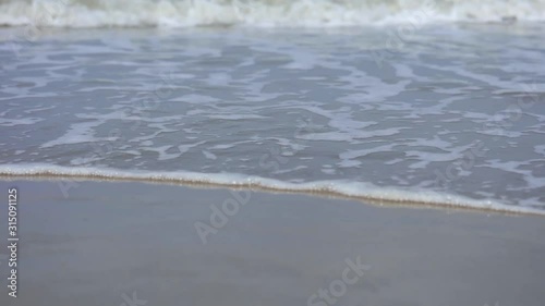 Sea waves close up during inflow on sand