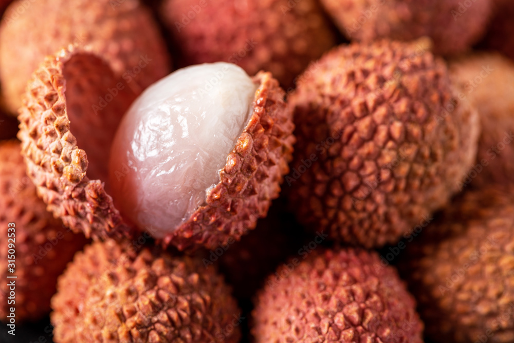 Fruits lychee background. Sliced lychee with white flesh closeup. Litchi chinensis Fruits lychee background. Sliced lychee with white flesh closeup. Litchi chinensis